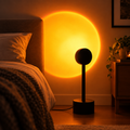 Sunset lamp projector casting a warm sunset glow across a bedroom wall